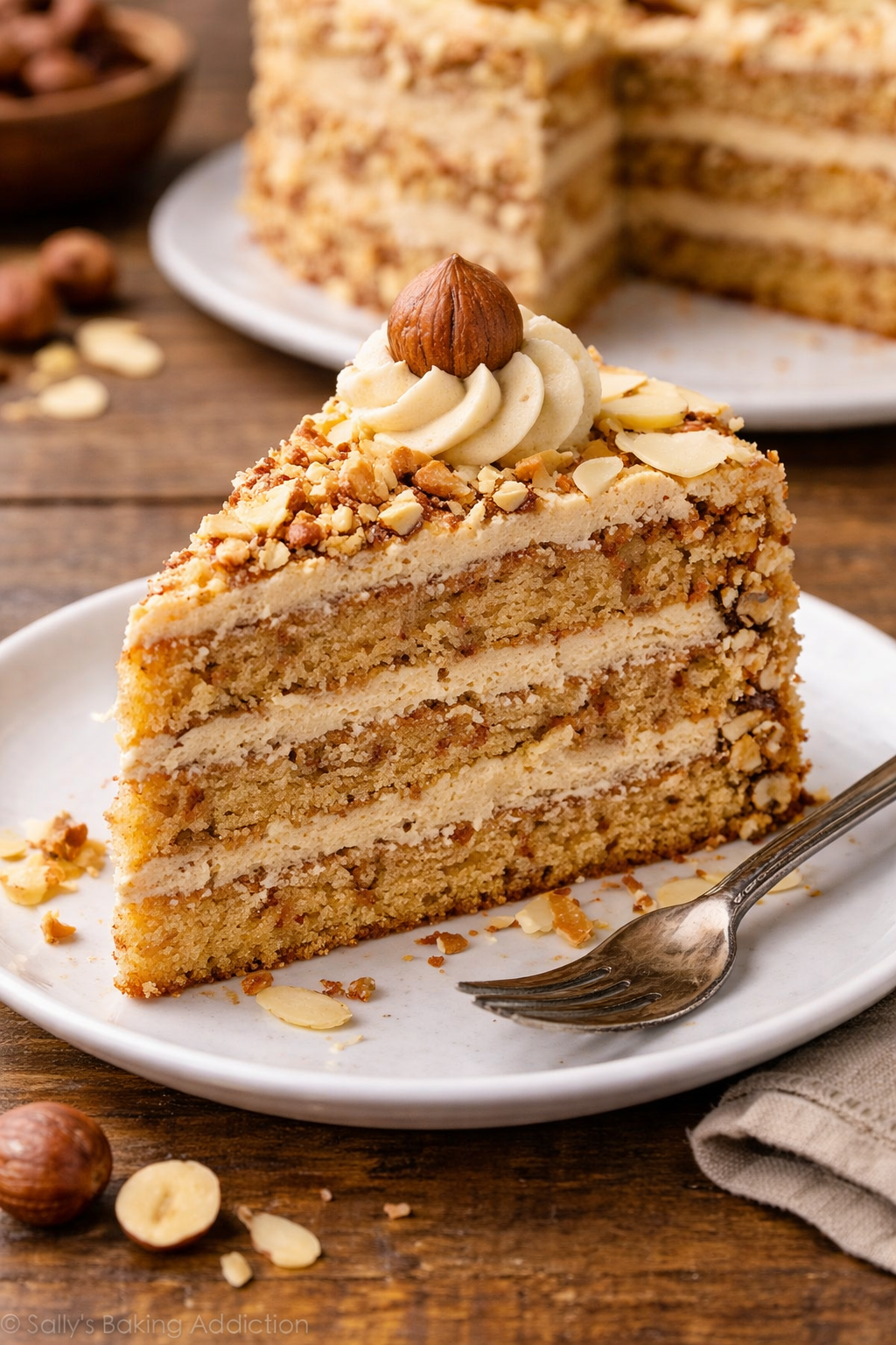 komad torte od lješnjaka i badema koji se jede viljuškom na tanjiru